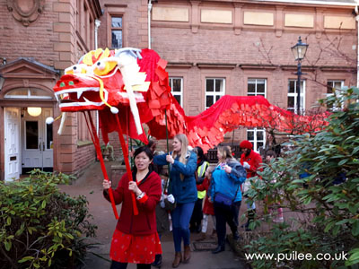 Artist Pui Lee leads the giant dragon through the parade